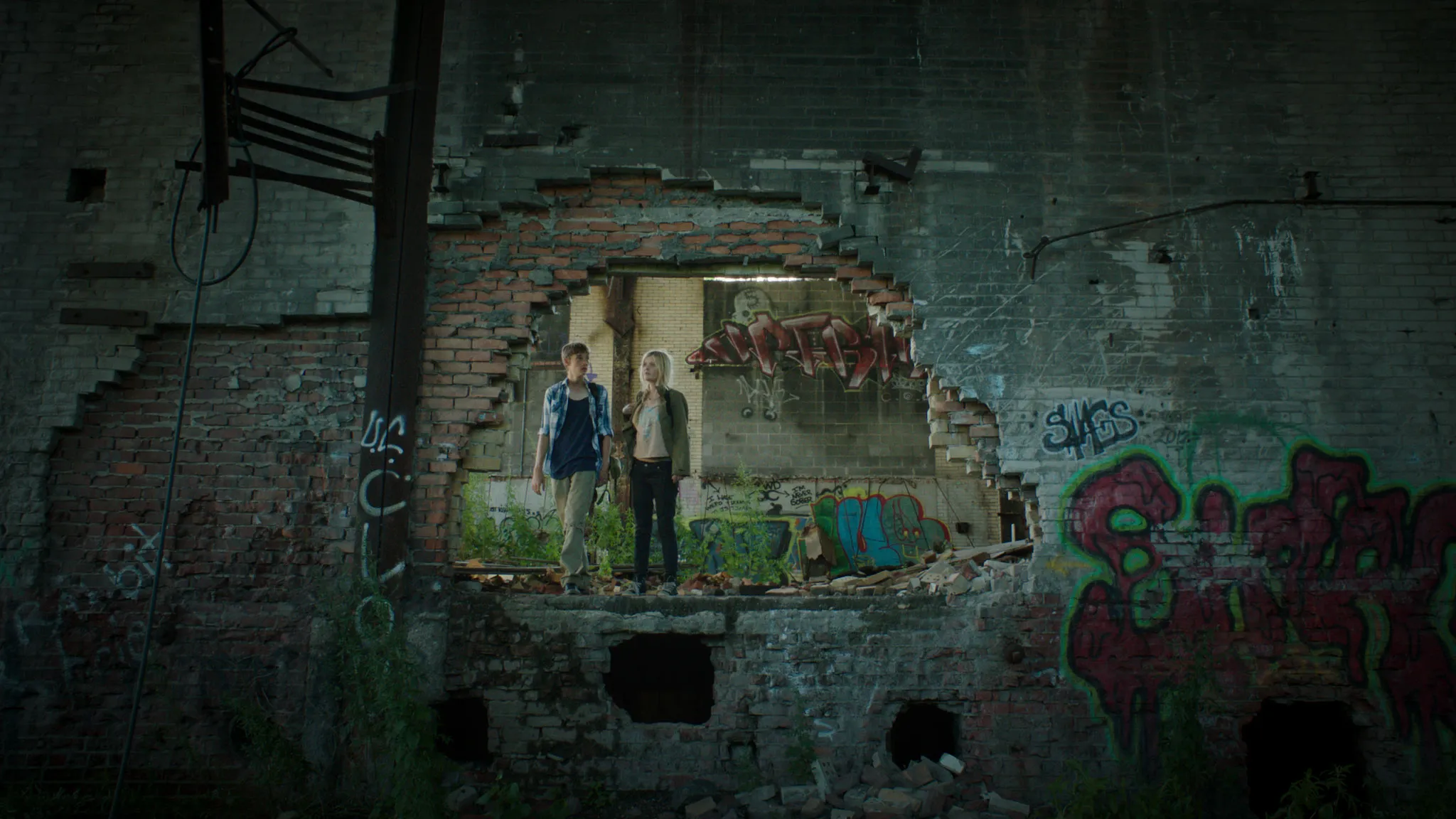 Two figures exploring a graffiti-covered ruin — Go North